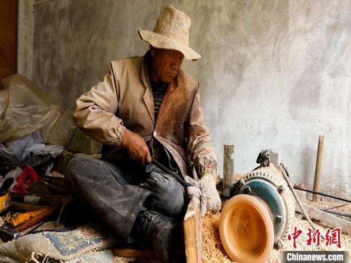 圖為手工藝人正在制作木碗?！?鄧海平 攝