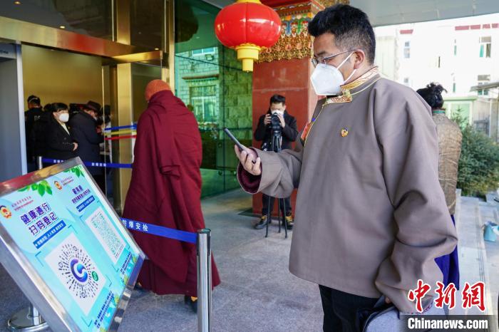 圖為政協(xié)委員掃場所碼進(jìn)入會場。　江飛波 攝