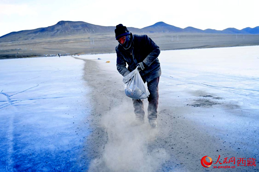 牧民在冰面上撒灰鋪成通道。人民網(wǎng) 李海霞攝