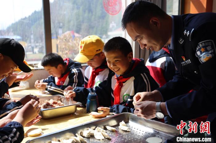 圖為亞東邊檢站民警與駐地小學(xué)生其樂融融包餃子。　胡利媛 攝