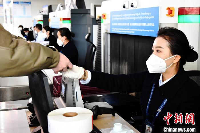 圖為機(jī)場工作人員為旅客辦理行李托運(yùn)。　周航 攝