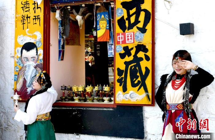 4月17日，游客身著藏式元素服裝在拉薩八廓街拍照留念。　李林 攝