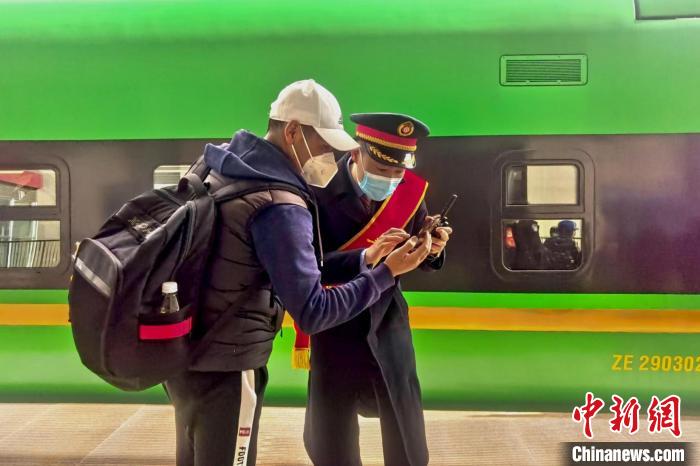 圖為日喀則火車站工作人員服務(wù)乘客?！《飞降?攝