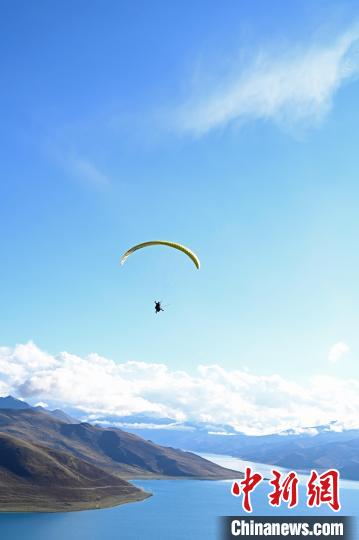 圖為在羊卓雍錯(cuò)，游客體驗(yàn)高空滑翔?！≮w朗 攝