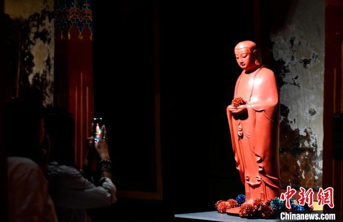 圖為觀眾正在欣賞展覽中的雕塑作品。