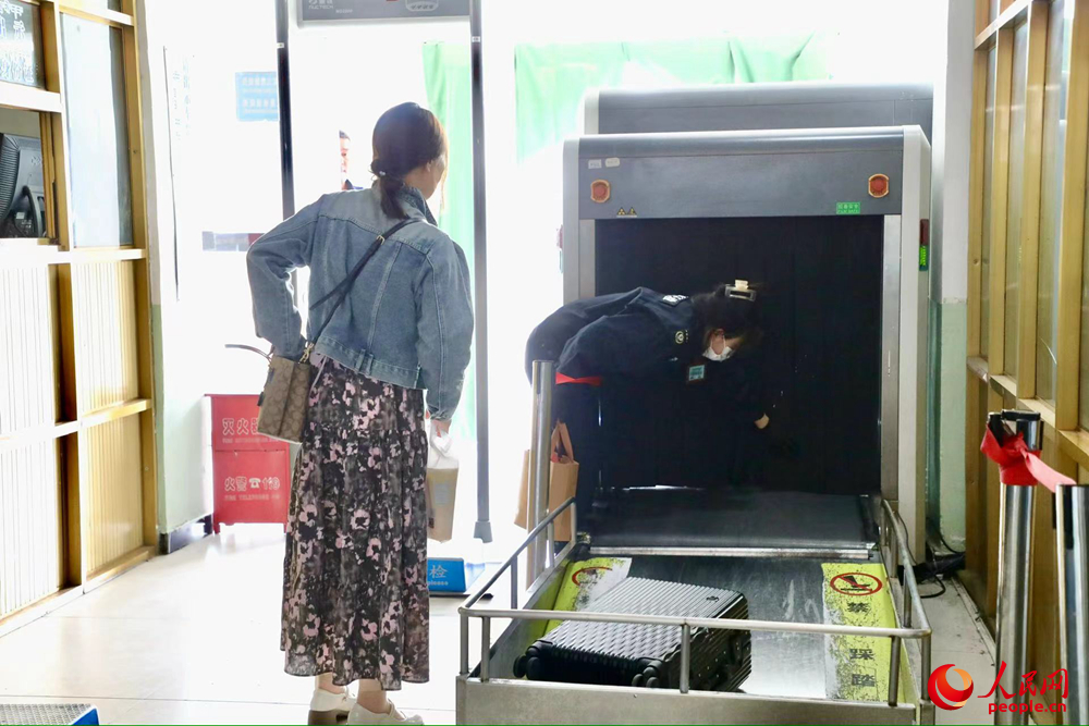 車(chē)站工作人員幫旅客提取行李。人民網(wǎng)記者 次仁羅布攝