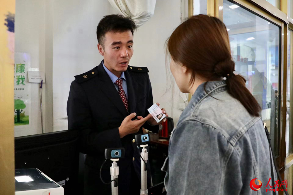 車(chē)站工作人員向旅客解答疑問(wèn)。人民網(wǎng)記者 次仁羅布攝