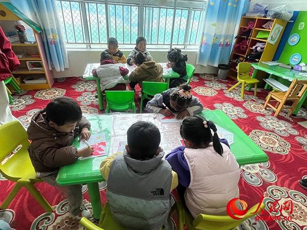 拉多村一所現(xiàn)代化幼兒園小班孩子們正在繪畫。張敏穎 攝