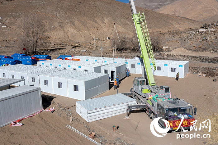 1月9日，在日喀則市定日縣長所鄉(xiāng)古榮村安置點，救援人員和施工人員合力抓緊搭建移動板房，確保受災(zāi)群眾溫暖過冬。人民網(wǎng)記者 翁奇羽攝