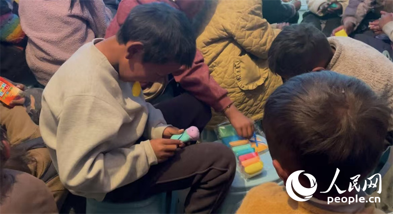 措果鄉(xiāng)塘仁村的孩子們正在用橡皮泥制作自己的情緒“小怪獸”。人民網(wǎng)記者 郝潔攝