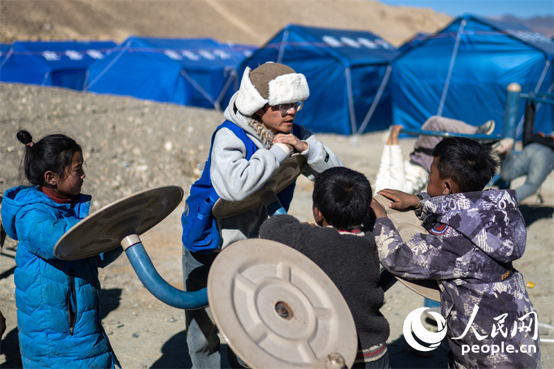 西藏星光社會(huì)工作服務(wù)中心社工久米旦增通過(guò)聊天談心，對(duì)孩子們進(jìn)行災(zāi)后心理疏導(dǎo)。人民網(wǎng)記者 翁奇羽攝