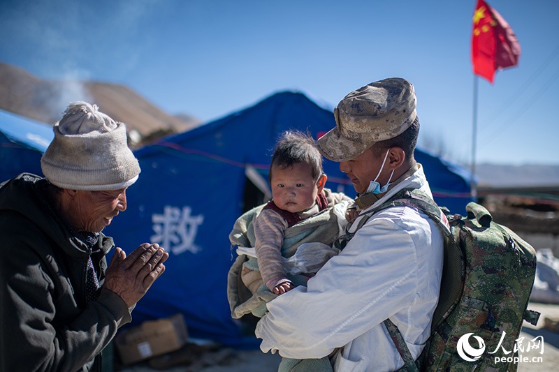1月9日，在定日縣長所鄉(xiāng)古榮村安置點，受災群眾感謝西藏軍區(qū)陸軍某部隊衛(wèi)生員的醫(yī)療救治。人民網記者 翁奇羽攝