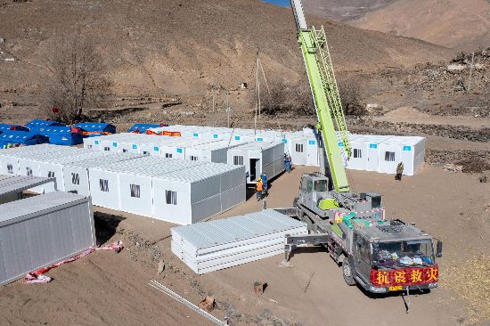 2025年1月9日，在定日縣長(zhǎng)所鄉(xiāng)古榮村安置點(diǎn)，救援人員和施工人員合力抓緊搭建移動(dòng)板房，確保受災(zāi)群眾溫暖過(guò)冬。人民網(wǎng)記者 翁奇羽攝