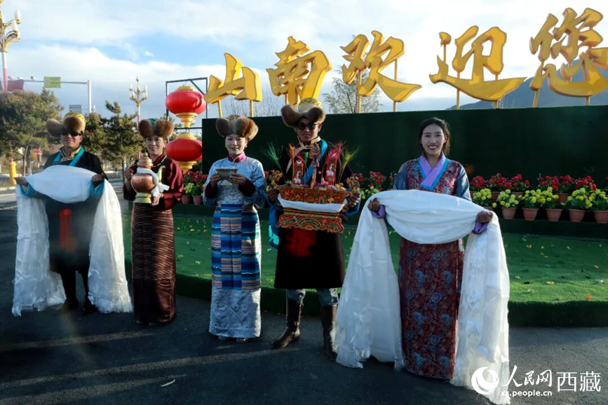 扎西曲登社區(qū)的居民在“山南歡迎您”標志前，手持潔白哈達和切瑪，列隊迎接來自區(qū)內外的游客，用最隆重的禮儀開啟一場沉浸式藏歷新年民俗體驗之旅。人民網記者 吳雨仁攝