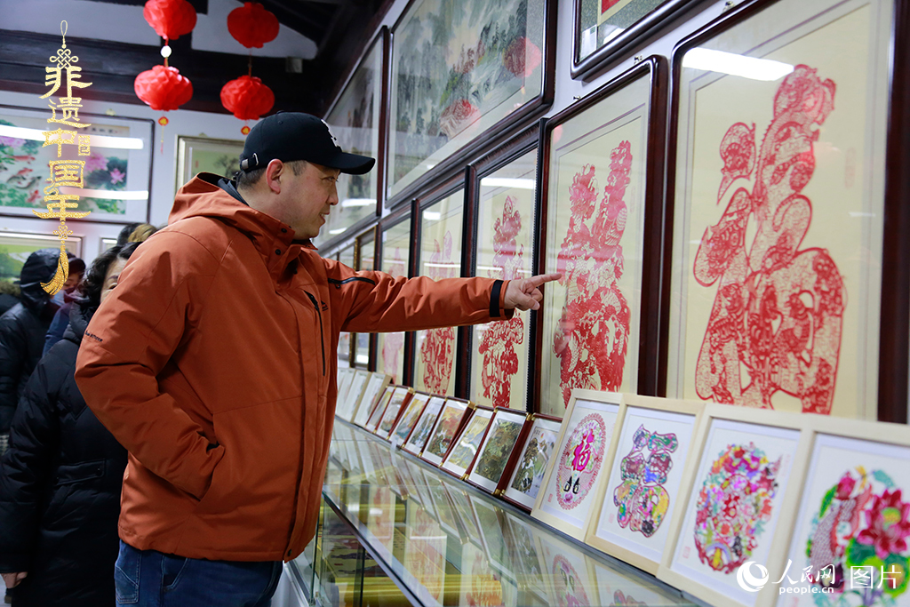 2025年1月23日，游客在天津楊柳青古鎮(zhèn)欣賞傳統(tǒng)剪紙作品，感受指尖上的古老藝術(shù)。人民網(wǎng)記者 崔新耀攝