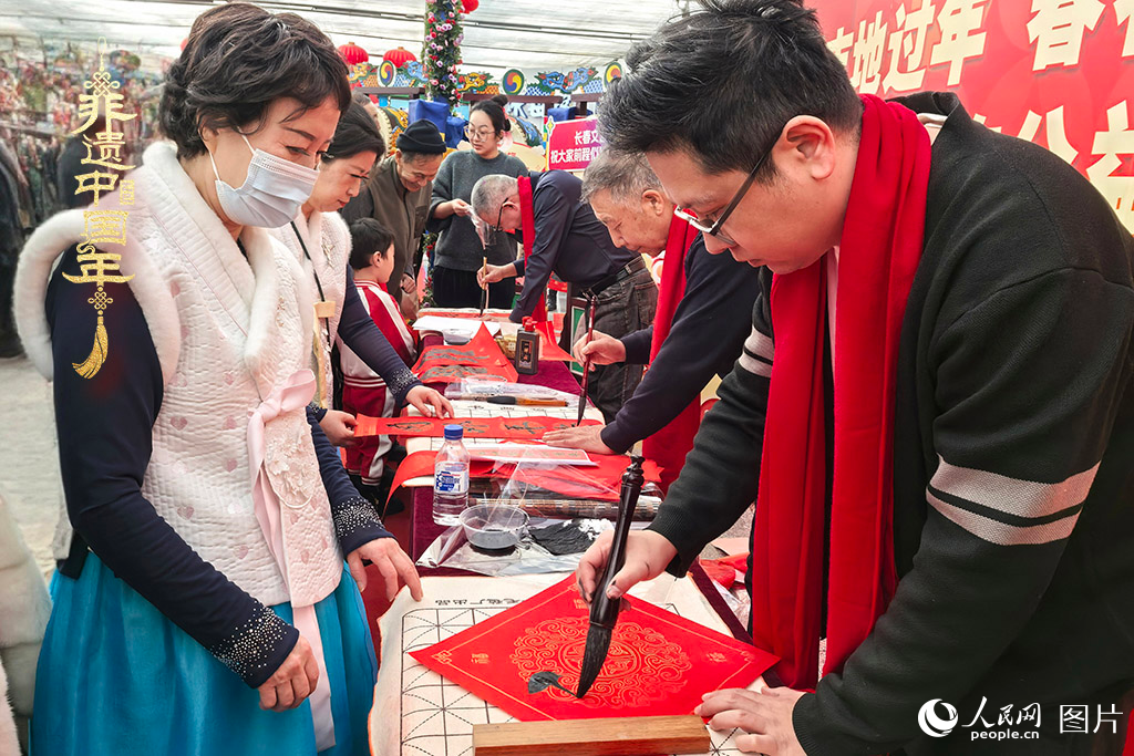 新春佳節(jié)之際，長春農(nóng)博園冬季展會(huì)火熱進(jìn)行，展廳內(nèi)，書法家現(xiàn)場(chǎng)書寫“?！弊?，市民游客紛紛上前迎春接“?！?。人民網(wǎng)記者 王海躍攝