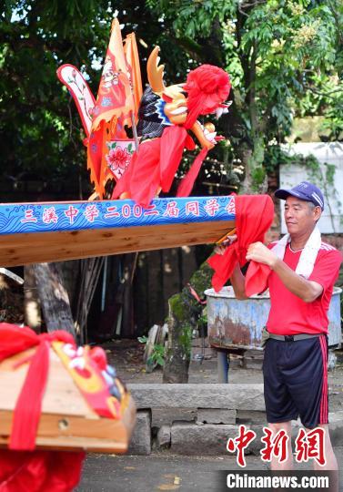 圖為5月29日，長樂江田鎮(zhèn)村民為即將入水的新龍舟系紅布?！埍?攝