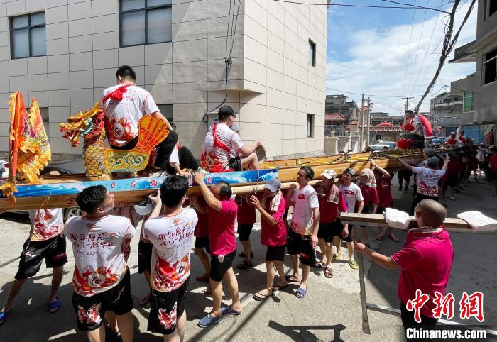 圖為5月29日，長樂江田鎮(zhèn)村民們肩扛著新龍舟舉行入水前游街儀式?！埍?攝