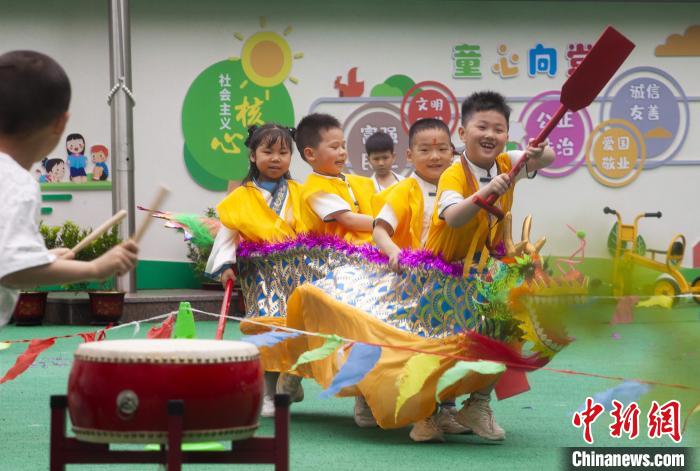 圖為龍舟賽游戲上，小伙伴們打鼓加油?！《^生 攝