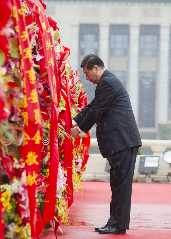 2013年10月1日上午，在首都各界代表向人民英雄紀(jì)念碑敬獻(xiàn)花籃儀式上，習(xí)近平整理花籃上的緞帶。